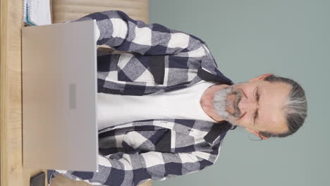 Vertical-video-of-The-old-man-who-can't-use-the-application-on-the-laptop.
